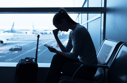 Mujer espera angustiada sentada en el aeropuerto